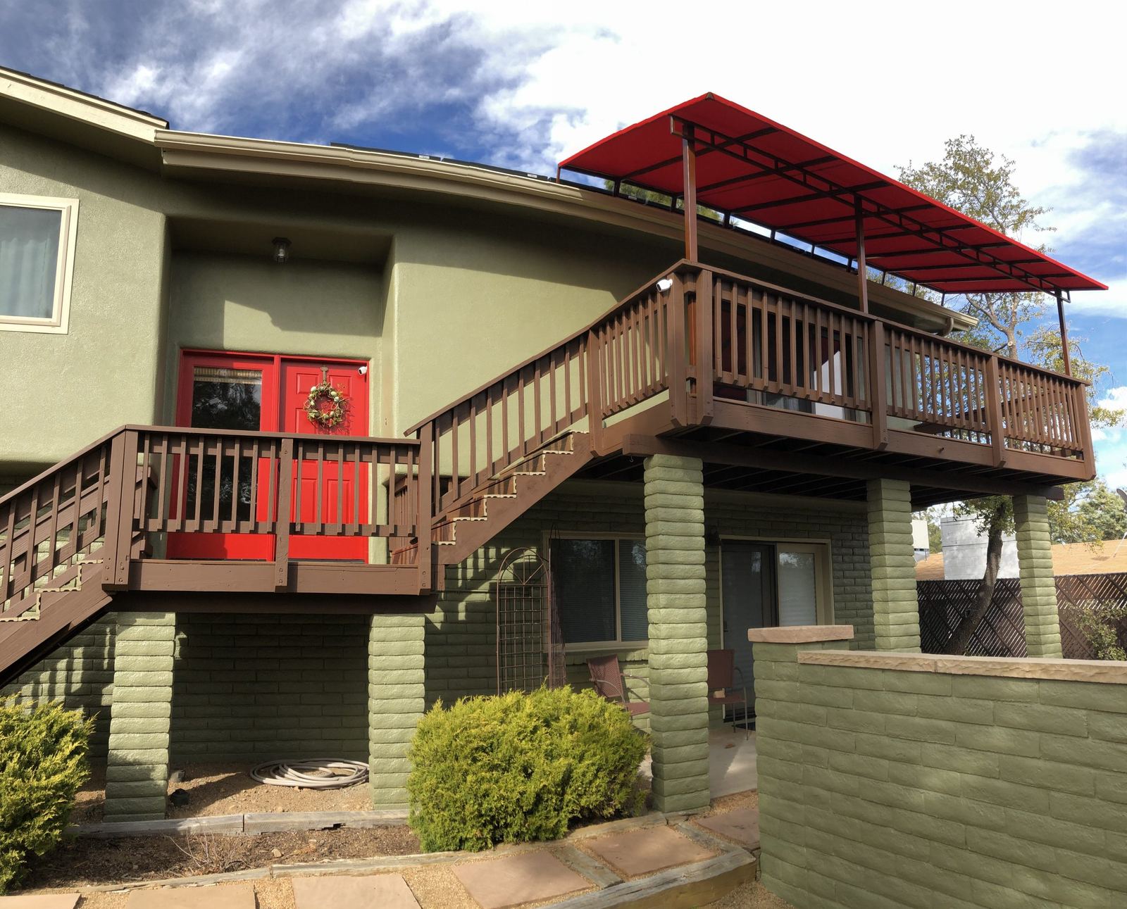 Red fixed-frame fabric awning over a second-story deck