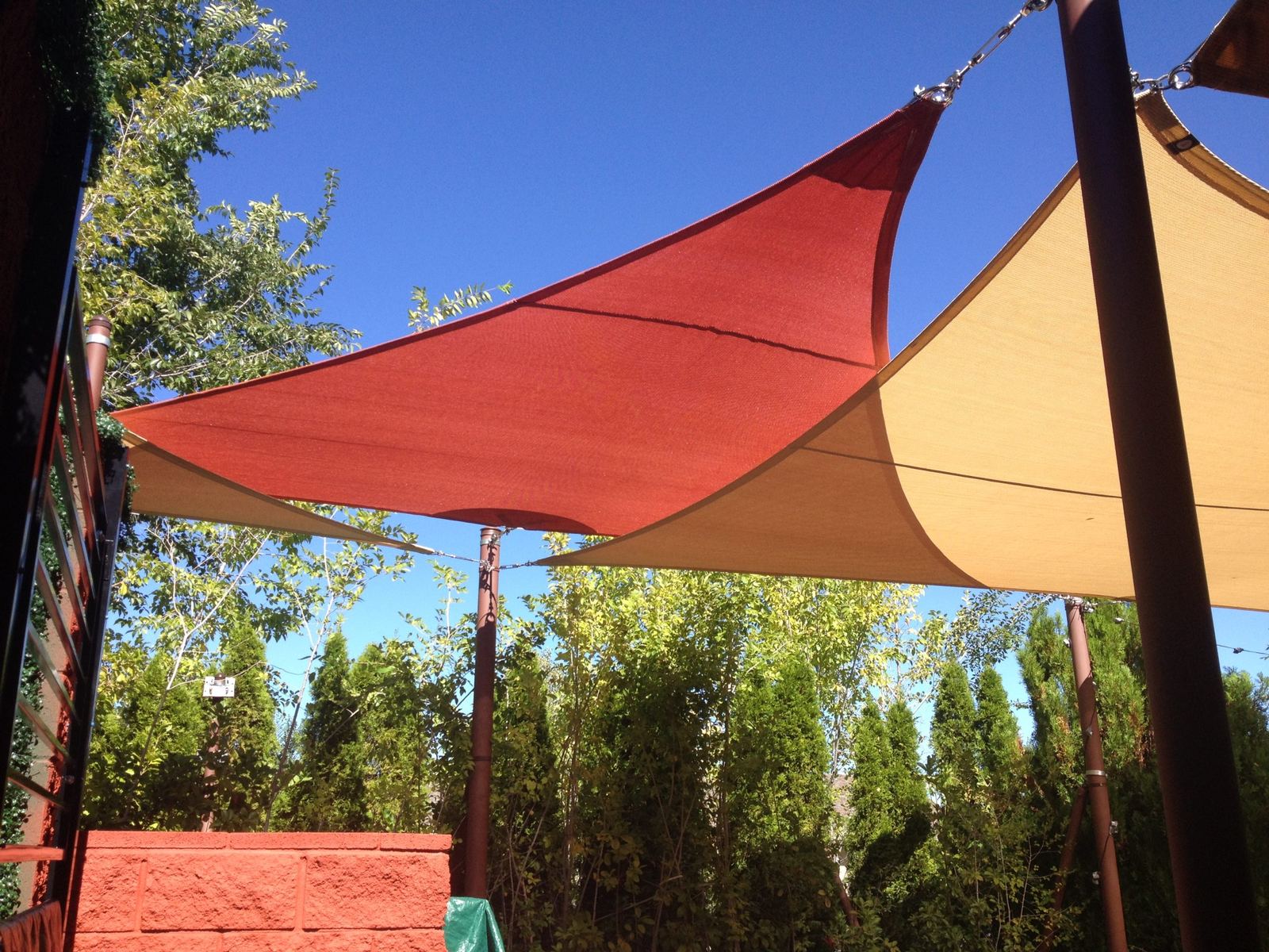 Rust and sand colored triangular shade sails against a blue Arizona sky
